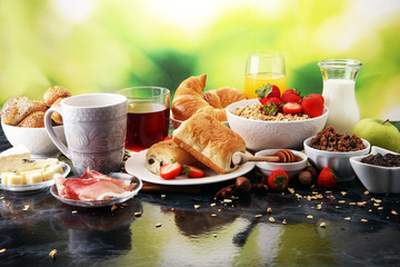 Breakfast served with coffee, orange juice, croissants and strawberry, jam and tea.