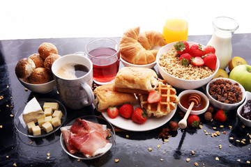 Breakfast served with coffee, orange juice, croissants and strawberry, jam and tea.