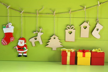 Christmas and New Year decorations from plywood. Christmas and New Year decorations from plywood and gift boxes on a light green wooden background.