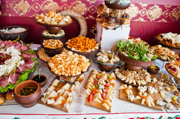 Cheese and meat decorated dishes on the wedding banquet.