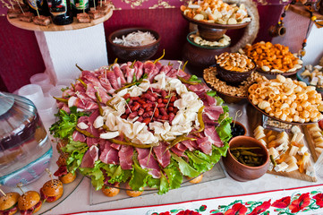 Cheese and meat decorated dishes on the wedding banquet.