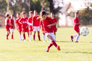 Obraz premium Kids soccer football - children players match on soccer field