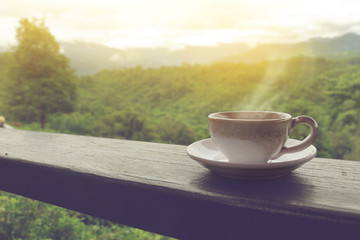 coffee cup on wood balcony in the morning with mountain view.