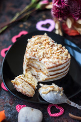 Beautiful dessert starting to eat, on black plate with metal spoon.