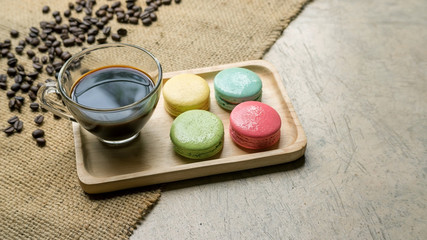 Colorful macaroons and a coffee on gray background.