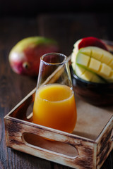 Glass with fresh mango juice in wooden box