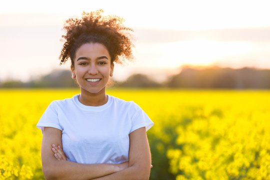 Happy Mixed Race African American Teenager Woman In Yellow Flowers