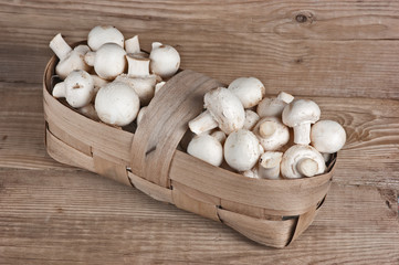 Basket with mushrooms on wooden background