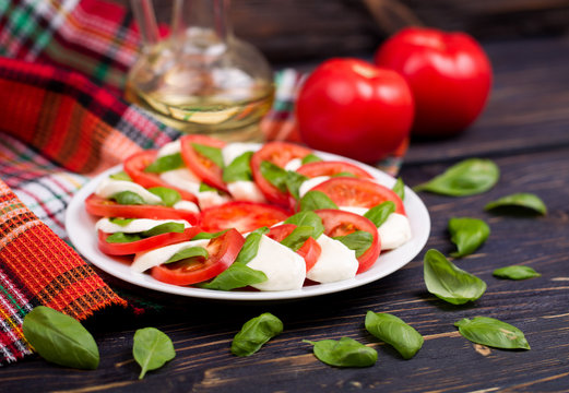 Delicious caprese salad with tomatoes and mozzarella cheese with basil leaves