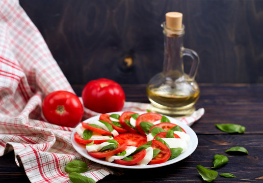 Delicious caprese salad with tomatoes and mozzarella cheese with basil leaves