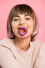Trendy woman posing with flower in mouth