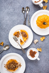 Thanksgiving day concept with homemade pumpkin tartlet, mini pie, on gray stone background. Healthy autumn food flat lay, copy space, top view.