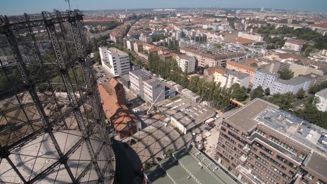 urbane Panorama Stadt Ansicht von Berlin &uuml;ber einem urbanen Gewerbe- und Industriegebiet am Gasometer mit Zug und Gleise im Hintergrund
- Copter Kameraflug und Weitwinkel