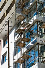 Working in a helmet on the scaffolding during the construction of high-rise residential buildings