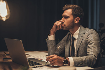 thoughtful businessman sitting at workplace