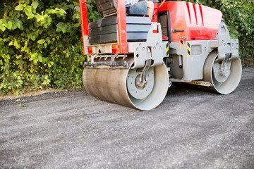 Fototapeta premium heavy machine rolls a new asphalt road
