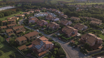Vista aerea di un complesso residenziale costituito da ville indipendenti e tanti alberi e giardini. Tra il verde della natura spicca il rosso dei tetti fatti con tegole.