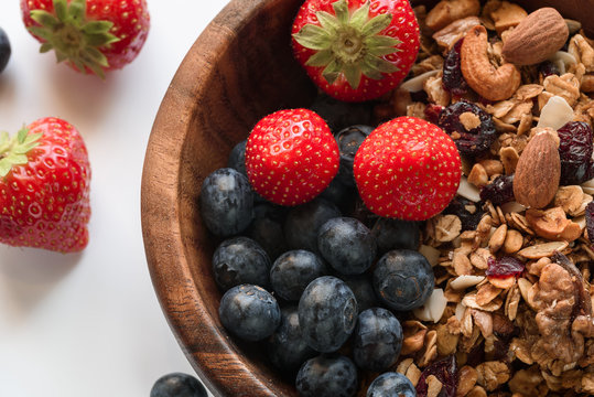 Healthy breakfast: homemade gramola with fresh blueberry and strawberry on white background