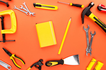 yellow notebook and reparement tools