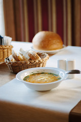 Soup at white ceramic plate at the table.