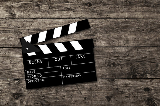 Movie clapperboard on wooden table background.