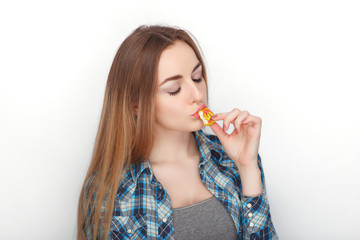 Beauty portrait of young adorable fresh looking blonde woman in blue plaid shirt posing with candy lollipop. Emotion and facial expression concept.