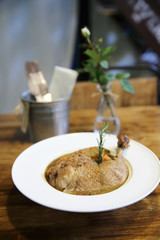 Coq au vin, chicken stewed in red wine with carrots and potatoes on wood background , France food