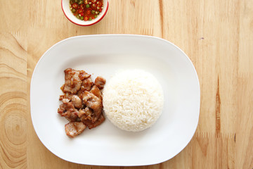 fried pork with garlic and rice on wood background , Thai food