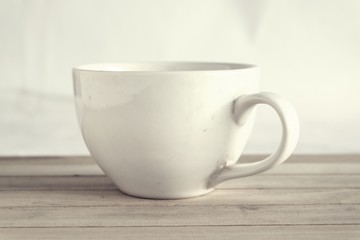 White coffee cup on wooden floor, Vintage style