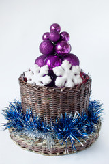 Christmas tree consisting of balls is standing in a wicker basket.