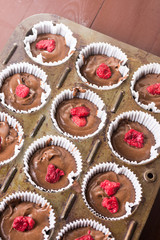 Raw chocolate muffin pastry dough with raspberry ready for baking