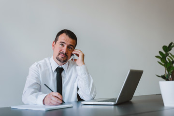 Mature man talking over the cell phone in modern office.