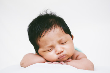 Newborn Baby Sleeping Peacefully Over White Bed 