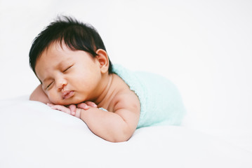 Newborn Baby Sleeping Peacefully Over White Bed 