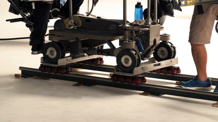 Production crew setting dolly track in studio.
