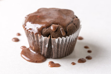 Chocolate cup cake muffin with melting topping chocolate cream on the white marble background