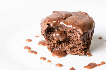 Sliced chocolate cup cake muffing with topping melting chocolate cream above white marble background