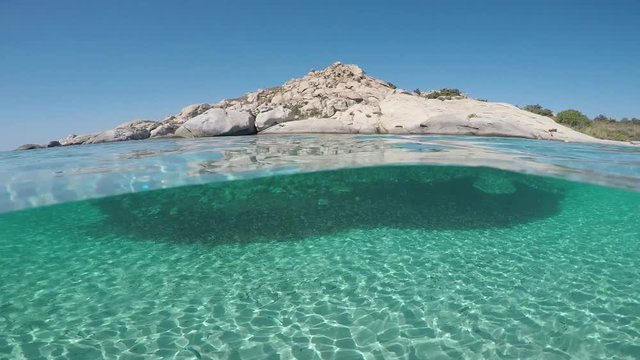 The bottom of an exotic beach on half underwater view