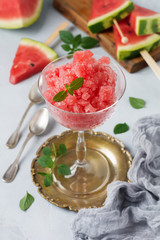Watermelon granite with mint, summer refreshing drink in glass on a gray concrete background. Selective focus.