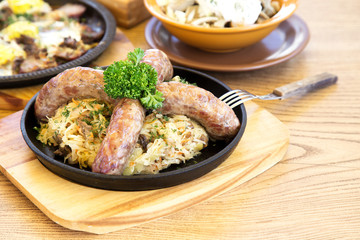 Sausages with sauerkraut on a frying pan