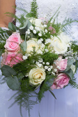 Beautiful white pink wedding bouquet in the hands of the bride