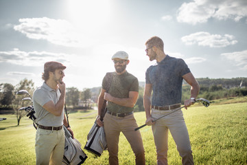 Golf player walking and carrying bag on course during summer game golfing