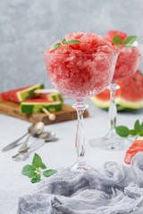 Watermelon granite with mint, summer refreshing drink in glass on a gray concrete background. Selective focus.