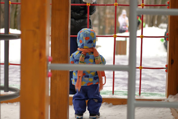 Kid play on the Playground in winter