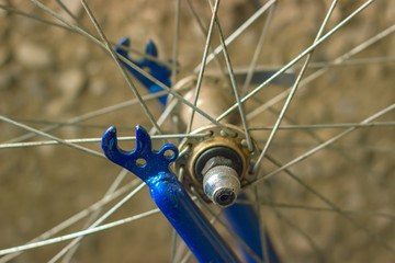 macro detail of a metal hub of a bike with blue forks