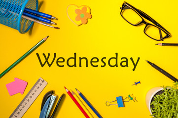 Wednesday. Office supplies or student outfit on yellow table. Business creative consept, top view