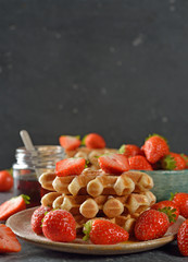 Traditional waffles with maple syrup and strawberries