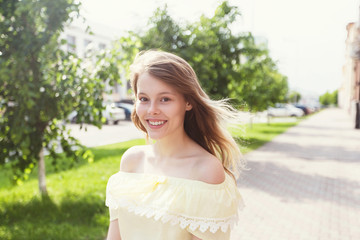 Smiling young pretty girl on sunny city street