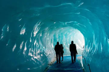 Crédence de cuisine en plexiglas Glaciers Silhouettes de personnes visitant la grotte de glace du glacier Mer de Glace, dans le massif de Chamonix Mont Blanc, les Alpes, France