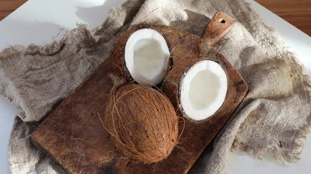 Coconut whole and half cut coconut on a rustic wooden background